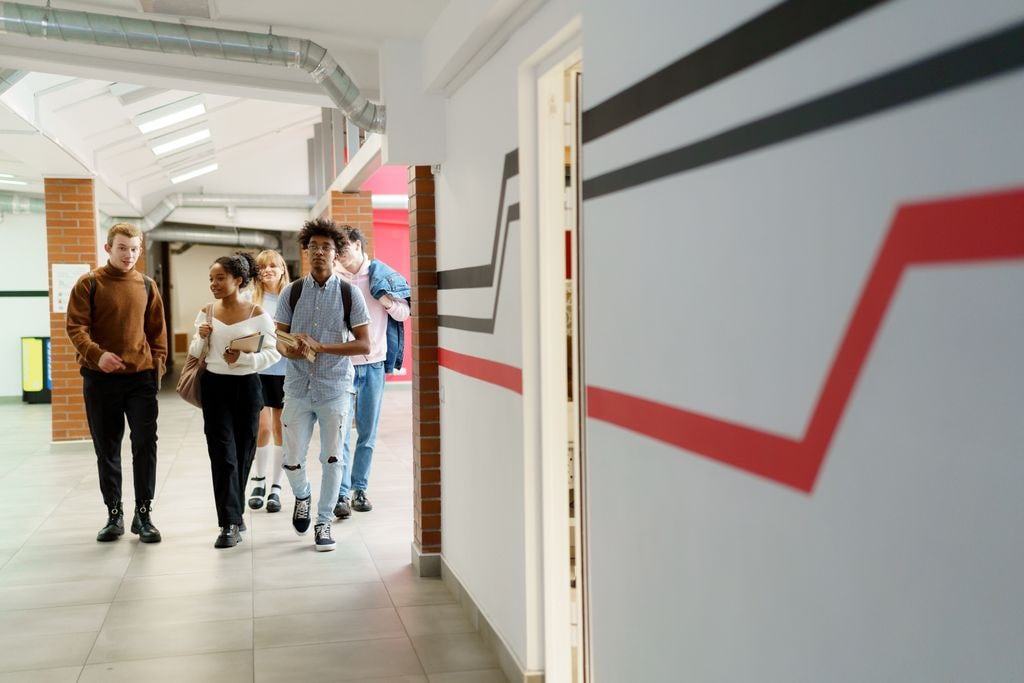 A group of secondary school students walking together through a school corridor